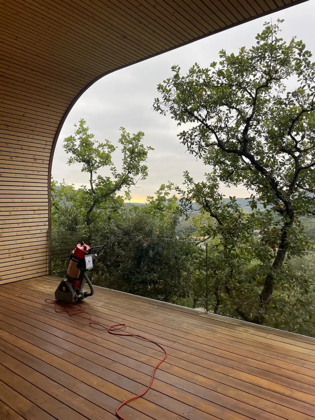 Monobrosse sur une terrasse en bois couverte, ouverte sur les arbres