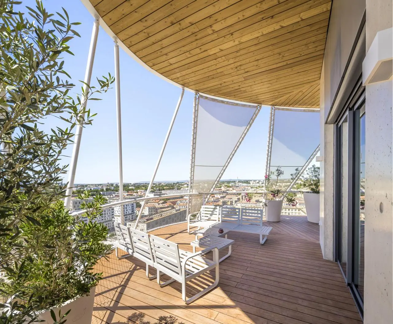 Terrasse en bois d'un appartement, sous un auvent, avec salon de jardin