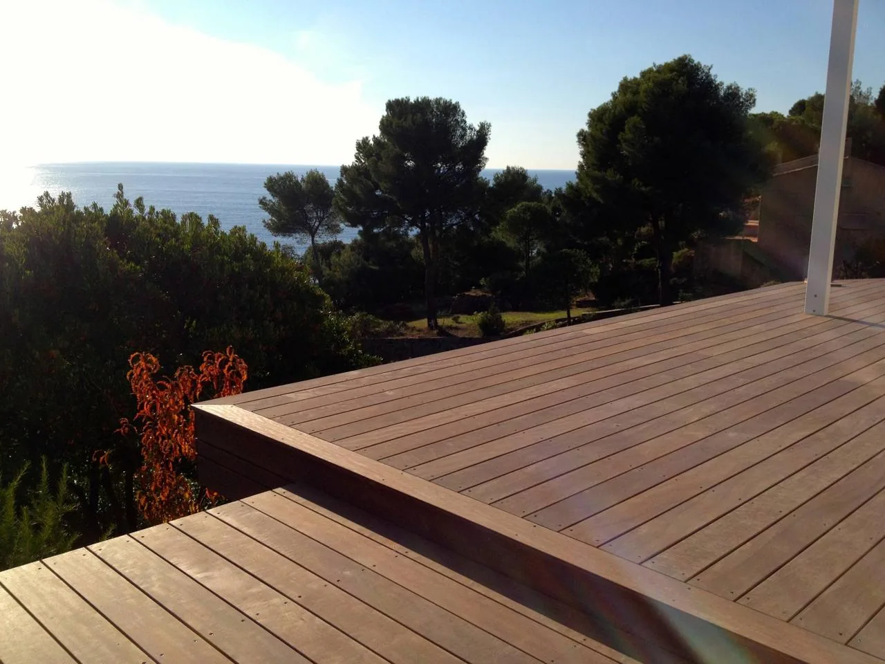 Terrasse en bois en surplomb, vue sur la mer et les pins