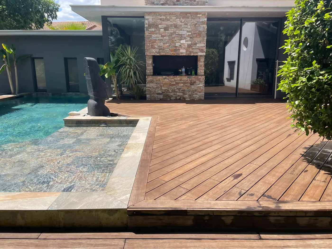 Terrasse en bois à l'angle d'une piscine, lames posées en biais
